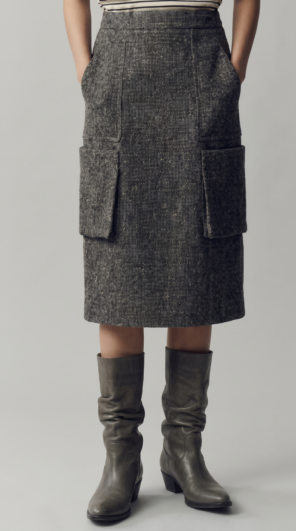 Look 11 — close-up of the grey textured pocket skirt styled with slouched leather boots.